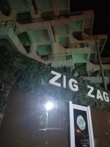 a sign on the side of a building at night at ZigZag in Mamaia Nord +2 photos