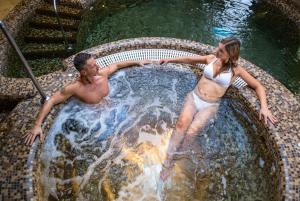 a man and a woman standing in a swimming pool at Wellness Hotel Laroba in Alsóörs