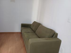 a green couch sitting in a living room at Apto central 3104 terreo com ar condicionado in Araçatuba +2 photos