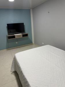 Un dormitorio con una cama y un televisor de pantalla plana. en Hermosa casa en Montebonito, Dosquebradas, en Dosquebradas