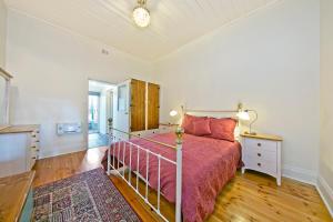 1 dormitorio con 1 cama con colcha roja en Vineyard Cottage BnB, en Gumeracha