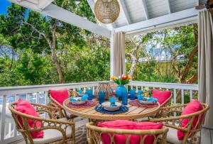 una mesa y sillas en un porche con vistas a los árboles en Serenity Oasiskayaksbikes!spapool!, en Long Point Key