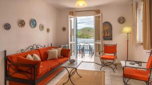 a living room with an orange couch and a table at Dioskouri II in Vathi