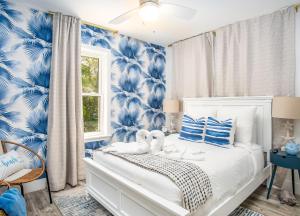 Un dormitorio con paredes azules y blancas y una cama blanca con flores azules. en Serenity Oasiskayaksbikes!spapool!, en Long Point Key 89 fotos más