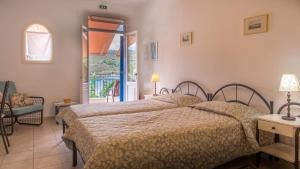a bedroom with two beds and a balcony at Dioskouri II in Vathi