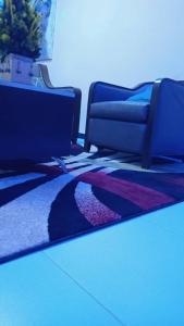 a room with two chairs and a rug on the floor at Résidence Hoteliere Marie Mbaye in Saly Portudal