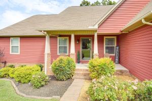 a red house with bushes in front of it at Hot Tub and Scenic Deck! Spacious Cookeville Retreat in Cookeville