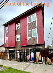 un edificio rojo con una valla delante en South west, en Seattle