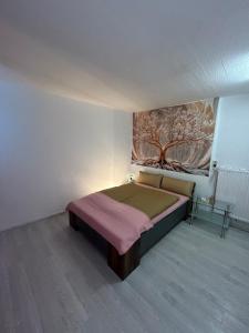 a bedroom with a bed and a painting on the wall at Tuhi Ferienwohnung in Bad Schwalbach