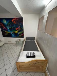 a bed in a room with a painting on the wall at Tuhi Ferienwohnung in Bad Schwalbach