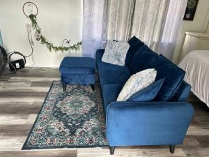 un divano blu e uno sgabello in un soggiorno di Cozy Studio 10 minutes from Siesta Key -perfect for couples a Sarasota