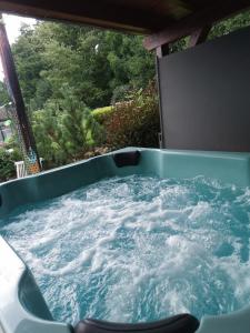 una vasca idromassaggio posta su un portico con acqua di Pure46 Minimalistisches Design, maximale Entspannung im Hottub a Bischofsheim an der Rhön