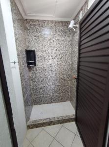 a bathroom with a shower with a glass door at Hostel de Niko Bombinhas in Bombinhas +17 photos