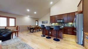 a kitchen with a refrigerator and a table with chairs at Red Slate Canyon - Modern 2-Story Condo in Mammoth Lakes