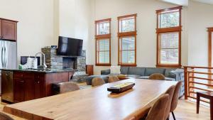 a living room with a wooden table and a couch at Red Slate Canyon - Modern 2-Story Condo in Mammoth Lakes +49 photos