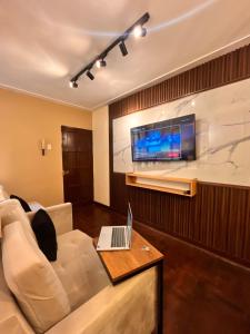 ein Wohnzimmer mit einem Sofa und einem Laptop auf dem Tisch in der Unterkunft Céntrico Dpto Puca Lima a 2 cuadras de Hospital Rebagliati y Real Plaza Salaverry in Lima