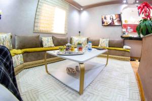 un salon avec un canapé et une table dans l'établissement Cozy apartment in Rabat Agdal, à Rabat