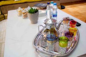 un plateau en argent avec des bouteilles et des verres sur une table dans l'établissement Cozy apartment in Rabat Agdal, à Rabat