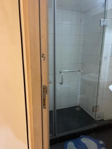 une salle de bain avec une douche avec une porte vitrée dans l'établissement Kings Luxury 1 bedroom at Gallery, à Accra 1 autre photo