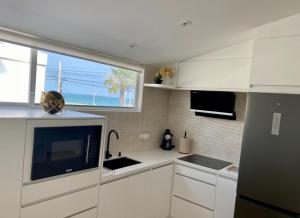 a kitchen with white cabinets and a large window at Moderno Dpto vista al mar, piscina in Santa Elena