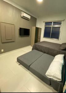 Un dormitorio con dos camas y un televisor de pantalla plana. en Pé na Areia Copacabana, en Río de Janeiro 52 fotos más