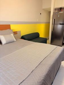 1 dormitorio con 1 cama grande y nevera en Pé na Areia Copacabana, en Río de Janeiro