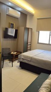 Un dormitorio con una cama y un televisor de pantalla plana. en Pé na Areia Copacabana, en Río de Janeiro