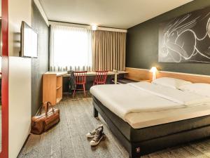 una habitación de hotel con una cama y un escritorio en Ibis Wien Mariahilf, en Viena