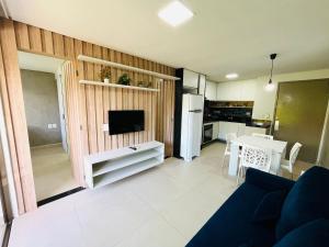 ein Wohnzimmer mit einer blauen Couch und einer Küche in der Unterkunft Lindo 2Qts Beira Mar - Beach Classe Muro Alto 6207 - Porto de Galinhas - By Anfitrião Legal in Porto De Galinhas