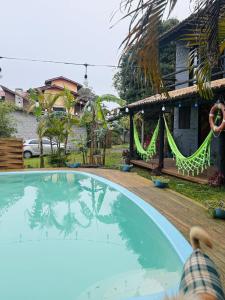 una piscina frente a una casa en Pousada pantera do rosa, en Imbituba