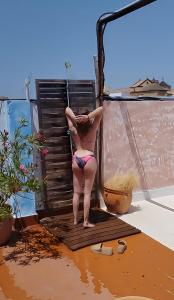 Una mujer en bikini parada en un balcón en BED FOR 4. TYPICAL QUIET AND AUTHENTIC AREA, en Córdoba