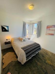 a bedroom with a bed and a window at Acacias PDD in Punta Del Diablo +7 photos