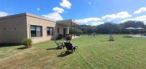 zwei Stühle stehen in einem Hof neben einem Haus in der Unterkunft Casa de Campo Vuelta de Obligado in Vuelta de Obligado