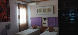 Dos camas en una habitación con ventanas moradas. en BED FOR 4. TYPICAL QUIET AND AUTHENTIC AREA, en Córdoba