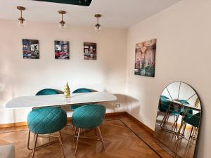 a dining room with a white table and green chairs at La casa di famiglia - elegante immobile di prestigio in centro in Turin +72 photos