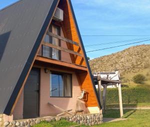 本塔纳山村Cabañas Ventana的一栋黑色屋顶的木结构房屋