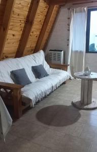 a white couch in a room with a table at Cabañas Ventana in Sierra de la Ventana
