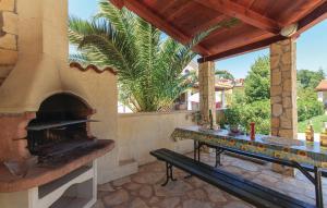 eine Außenterrasse mit einem Pizzaofen und einem Tisch in der Unterkunft Oliva Holiday Apartment in Banjole