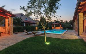 einen Hinterhof mit einem Pool und einem Baum und einem Haus in der Unterkunft Oliva Holiday Apartment in Banjole