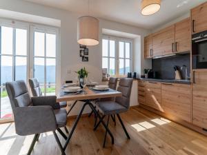 Una cocina con una mesa y sillas de madera. en Lärchenhof Top 01, en Mauterndorf