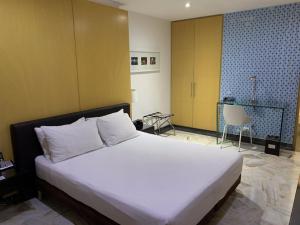 a bedroom with a large white bed in a room at Hotel King Versalles in Cali