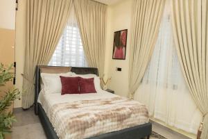 a bedroom with a bed and two windows at Bigchills Bills apt in Apenkwa