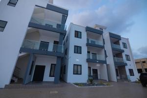 a large white building with balconies on it at Bigchills Bills apt in Apenkwa