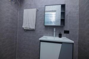 a bathroom with a white sink and a mirror at Bigchills Bills apt in Apenkwa +40 photos