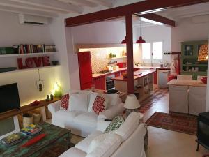 a living room with white couches and a kitchen at Casa Bitxu in Mahón