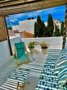 un patio avec deux chaises et un lit et un pare-soleil dans l'établissement Casa Bitxu, à Port Mahon
