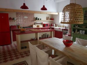 a kitchen with a wooden table and red cabinets at Casa Bitxu in Mahón