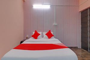 a bedroom with a white bed with red pillows at Hotel O Ki & Kaa in Dānāpur