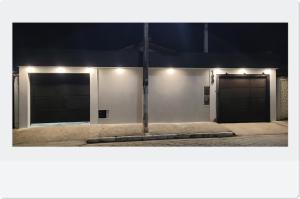 two garage doors on a building at night at Aliança da Fé in Cachoeira Paulista