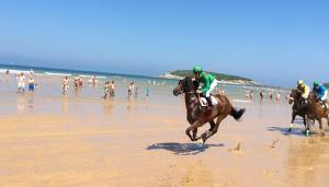 un grupo de personas montando a caballo en la playa en Apartamento de Playa Somo Loredo en Loredo